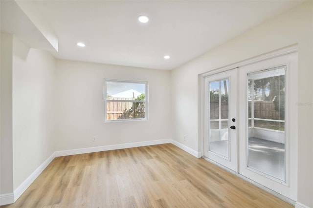 spare room with french doors, recessed lighting, light wood-style flooring, and baseboards