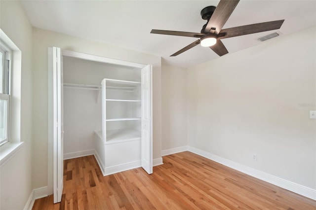 unfurnished bedroom featuring ceiling fan, light hardwood / wood-style floors, and a closet