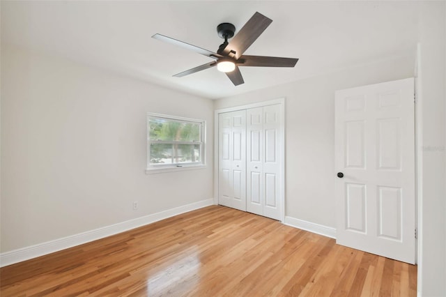 unfurnished bedroom featuring ceiling fan, a closet, light wood-type flooring, and baseboards