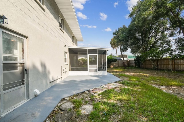 view of yard featuring a patio area, a sunroom, and a fenced backyard