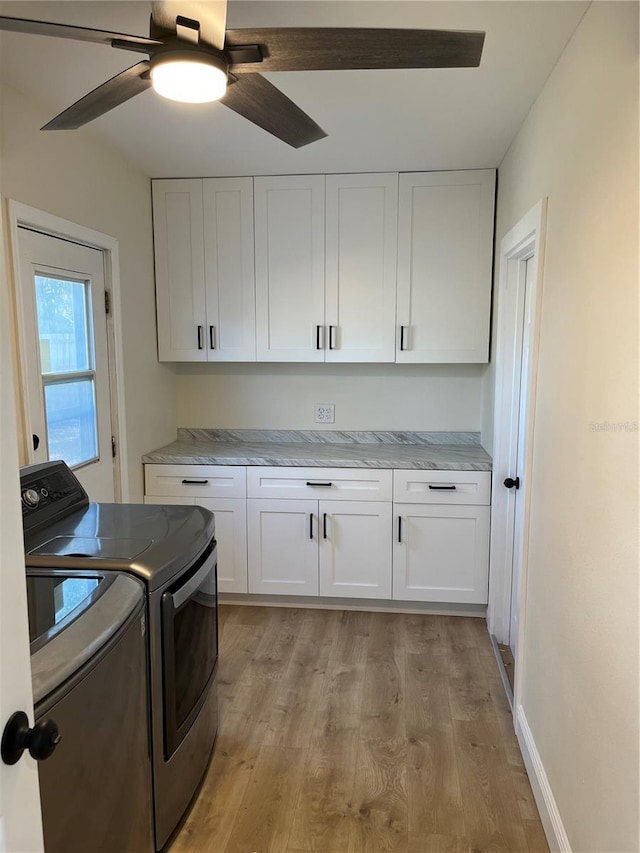 clothes washing area with cabinets, ceiling fan, independent washer and dryer, and light hardwood / wood-style flooring