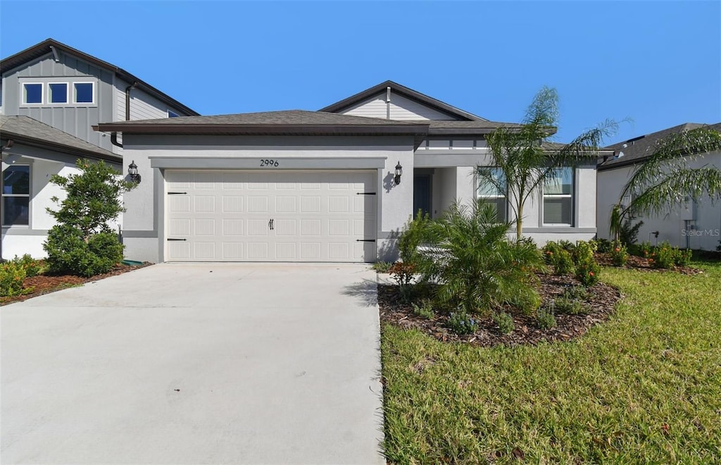 single story home with a garage and a front lawn