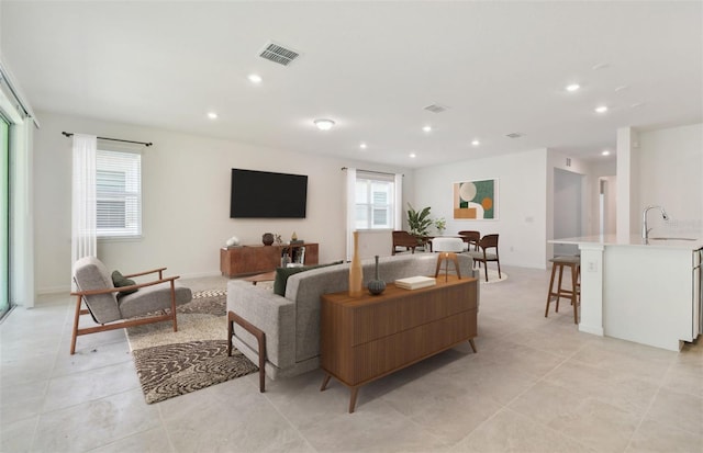 living room featuring sink and light tile patterned floors