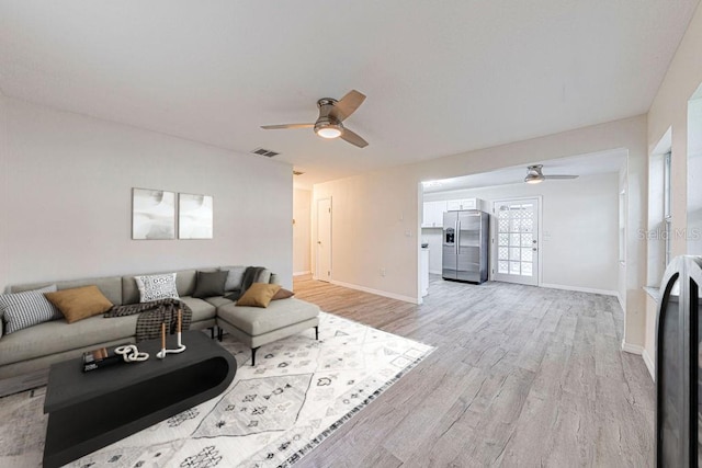 living room featuring ceiling fan and light hardwood / wood-style floors