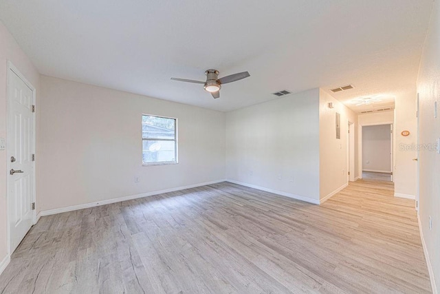 empty room with ceiling fan and light hardwood / wood-style flooring