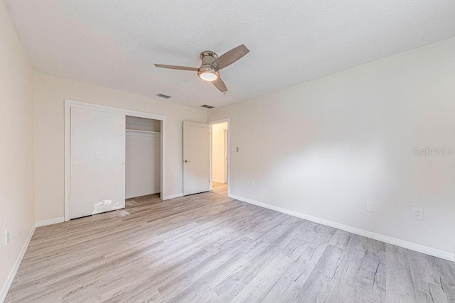 unfurnished bedroom featuring ceiling fan, a closet, and light hardwood / wood-style floors