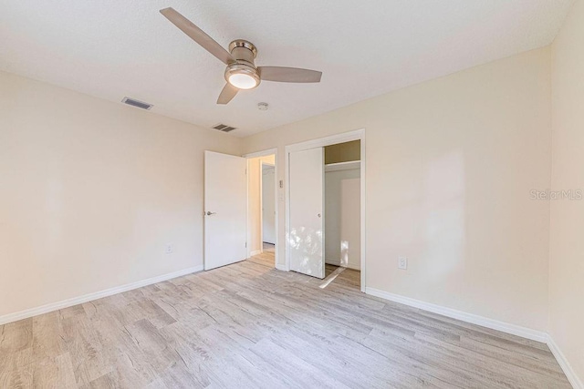 unfurnished bedroom featuring ceiling fan, light wood-type flooring, and a closet