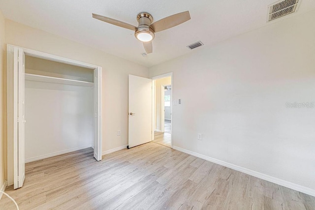 unfurnished bedroom with ceiling fan, light hardwood / wood-style flooring, and a closet