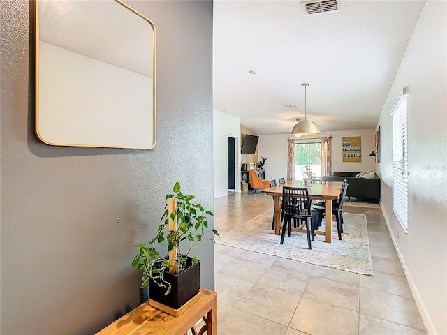 dining room with lofted ceiling, light tile patterned floors, baseboards, and visible vents