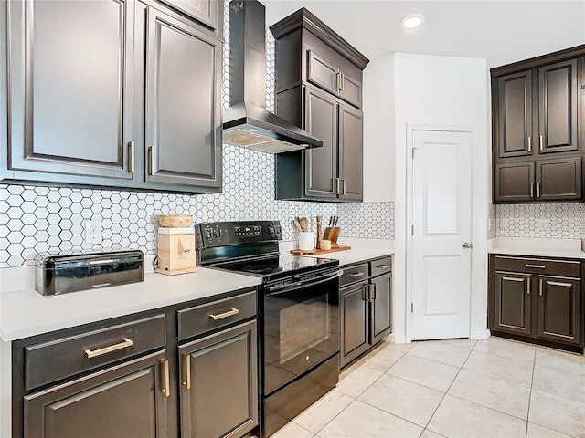 kitchen with light countertops, black range with electric cooktop, and wall chimney exhaust hood