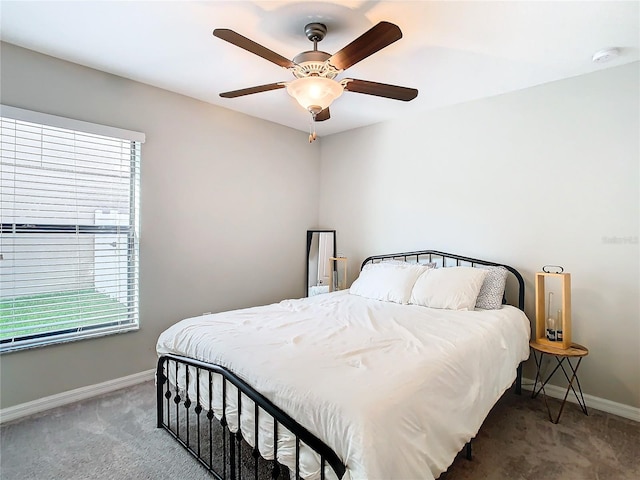 carpeted bedroom with ceiling fan and baseboards