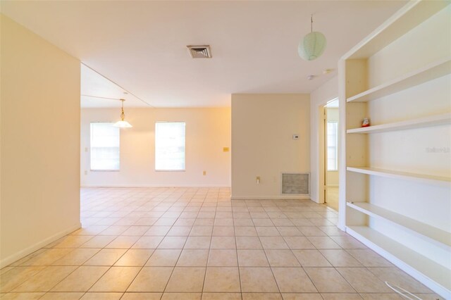 tiled spare room featuring a healthy amount of sunlight