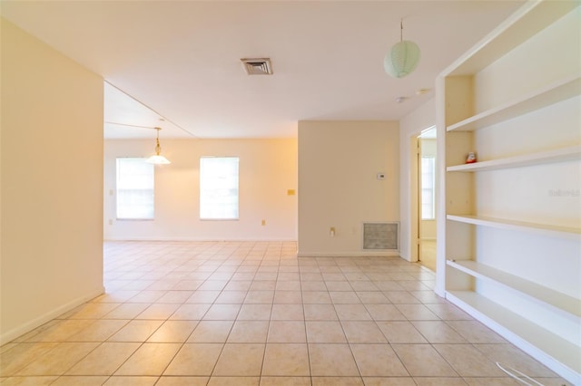 unfurnished room with light tile patterned floors, baseboards, visible vents, and built in features