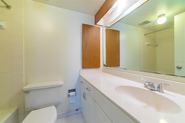 full bathroom featuring vanity, toilet, tiled shower / bath, and tile patterned flooring