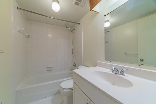 full bathroom with tiled shower / bath combo, tile patterned floors, vanity, and toilet