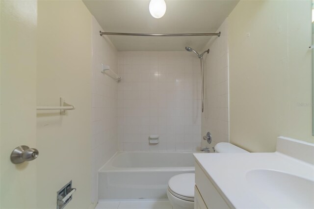 full bathroom featuring tile patterned flooring, toilet, vanity, and tiled shower / bath