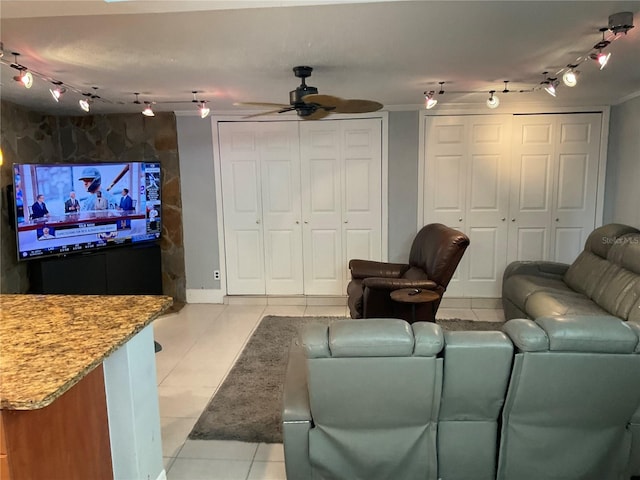 tiled living room with ceiling fan, rail lighting, and ornamental molding