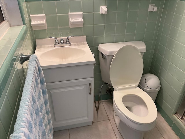 bathroom featuring tile patterned flooring, tile walls, toilet, and vanity