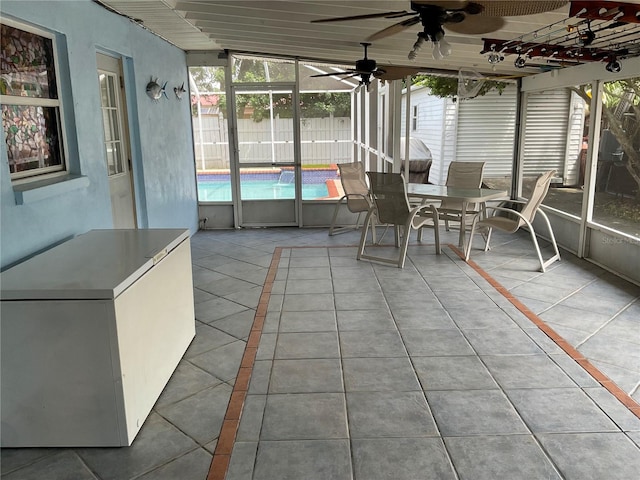 unfurnished sunroom with ceiling fan