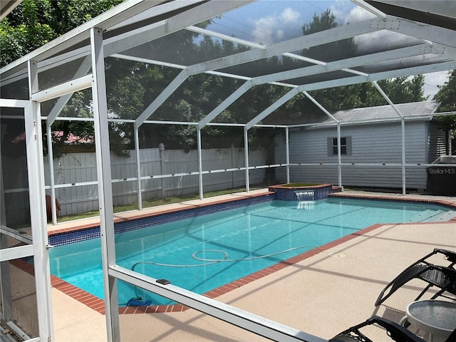 view of swimming pool featuring glass enclosure, an in ground hot tub, and a patio