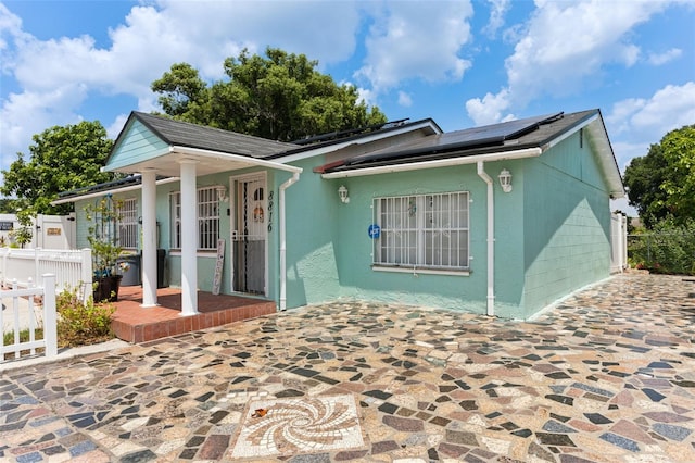 view of front of house featuring a patio and solar panels