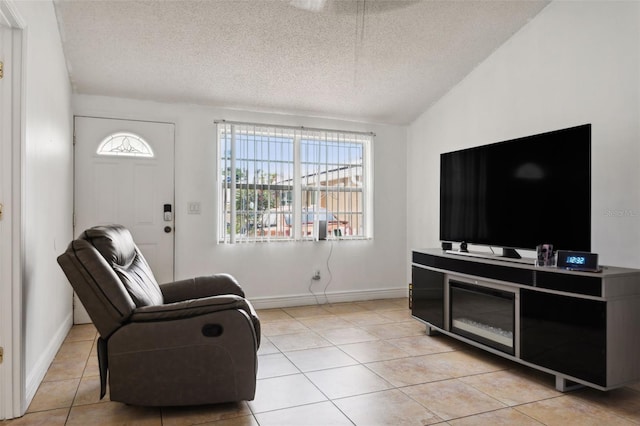 interior space featuring a textured ceiling, lofted ceiling, and light tile patterned floors