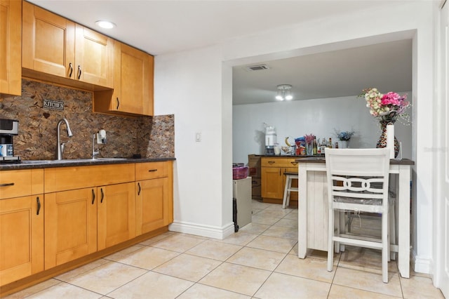 kitchen featuring light tile patterned floors, sink, and tasteful backsplash