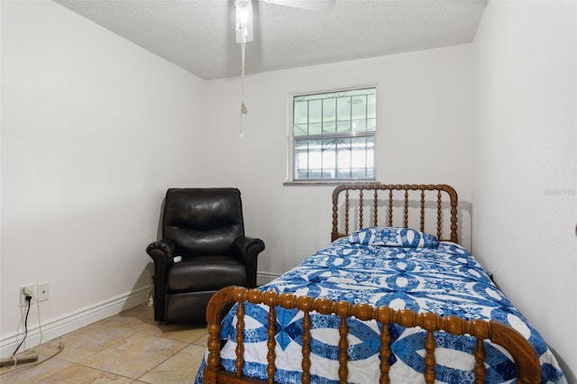 bedroom featuring a ceiling fan, a textured ceiling, and baseboards