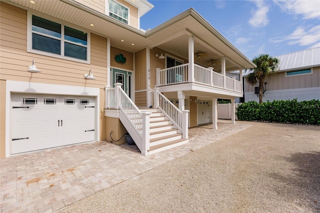 210 Lakeview Dr, Anna Maria, FL 34216 - property entrance featuring a garage, a ceiling fan, and decorative driveway