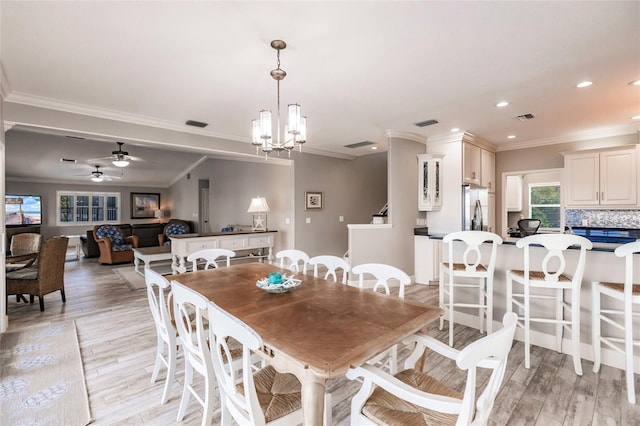 210 Lakeview Dr, Anna Maria, FL 34216 - dining area with ceiling fan with notable chandelier, visible vents, light wood-style floors, and ornamental molding