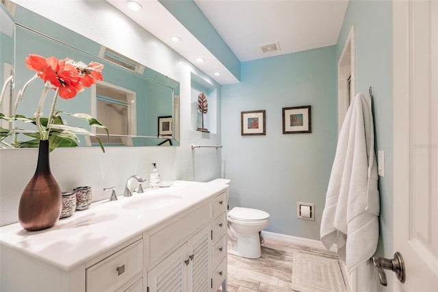 210 Lakeview Dr, Anna Maria, FL 34216 - full bathroom featuring toilet, vanity, wood finished floors, baseboards, and visible vents