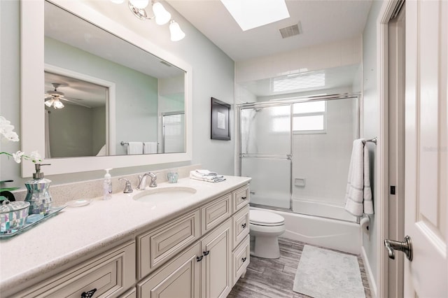 210 Lakeview Dr, Anna Maria, FL 34216 - full bath featuring visible vents, toilet, wood finished floors, vanity, and shower / bath combination with glass door