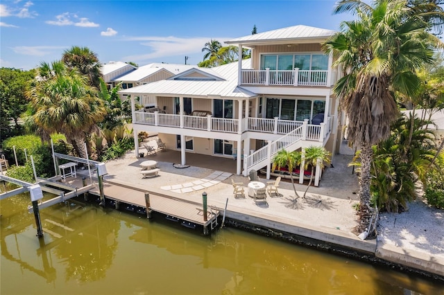 210 Lakeview Dr, Anna Maria, FL 34216 - rear view of property featuring a patio, a water view, metal roof, and boat lift