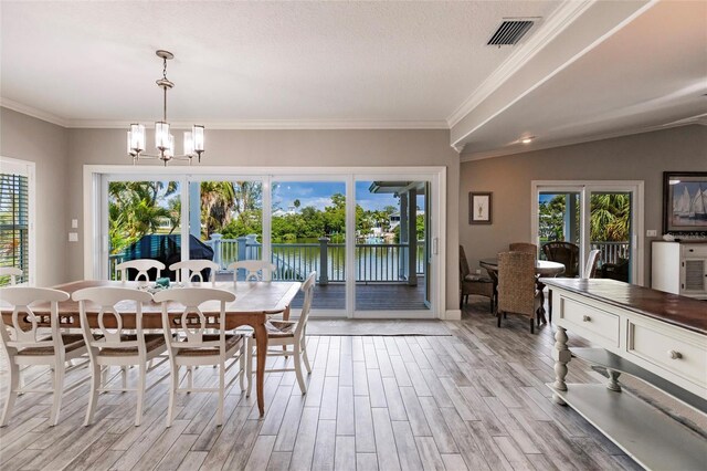 210 Lakeview Dr, Anna Maria, FL 34216 - dining space with light wood finished floors, visible vents, plenty of natural light, and an inviting chandelier