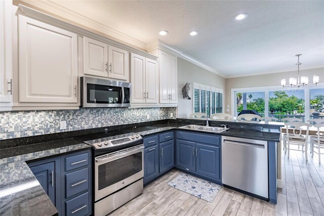 210 Lakeview Dr, Anna Maria, FL 34216 - kitchen with a sink, tasteful backsplash, an inviting chandelier, stainless steel appliances, and blue cabinetry