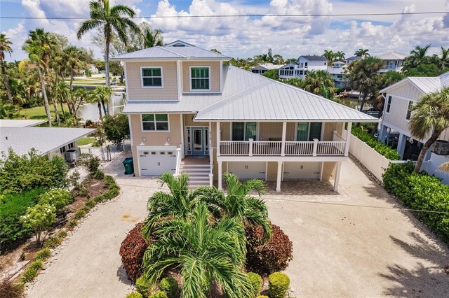 210 Lakeview Dr, Anna Maria, FL 34216 - raised beach house with metal roof, a garage, concrete driveway, and stairway