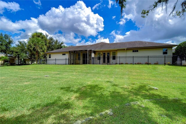 rear view of property with a lawn