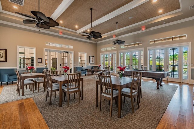 dining room with beam ceiling, wood ceiling, a towering ceiling, and french doors