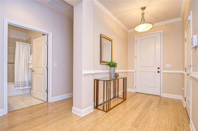 entryway featuring light hardwood / wood-style flooring and ornamental molding