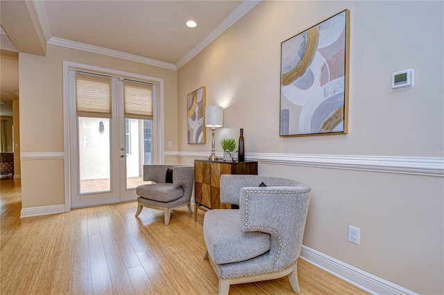 living area with ornamental molding, french doors, and light hardwood / wood-style flooring