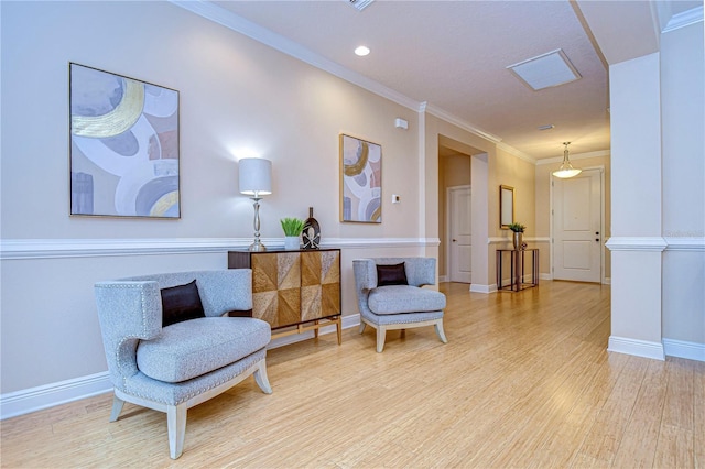 sitting room featuring crown molding and light hardwood / wood-style flooring