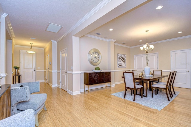 dining room featuring a notable chandelier, crown molding, and light hardwood / wood-style flooring