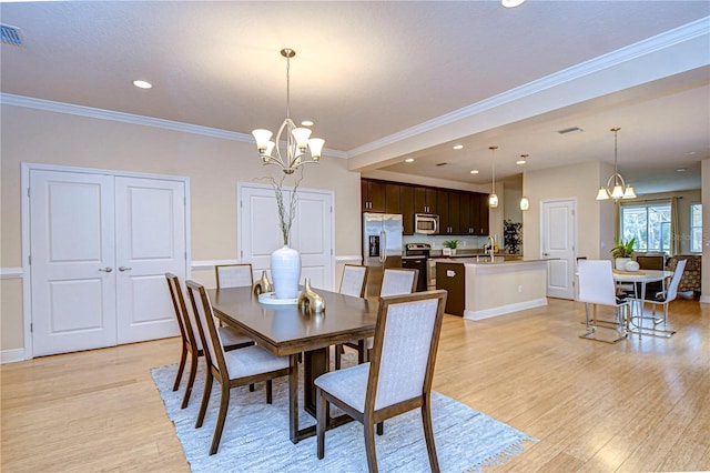 dining room with light wood-type flooring, crown molding, and a chandelier