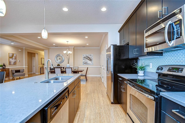 kitchen with sink, hanging light fixtures, stainless steel appliances, an inviting chandelier, and backsplash