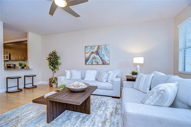 living room featuring light wood-type flooring and ceiling fan