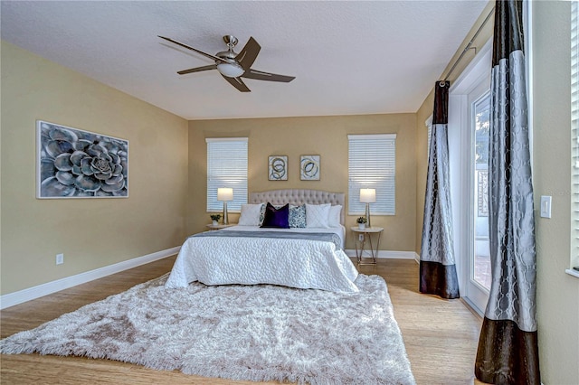 bedroom with multiple windows, a textured ceiling, light hardwood / wood-style flooring, and ceiling fan