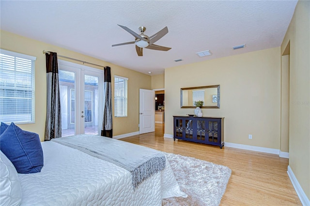 bedroom with french doors, a textured ceiling, light hardwood / wood-style flooring, and ceiling fan