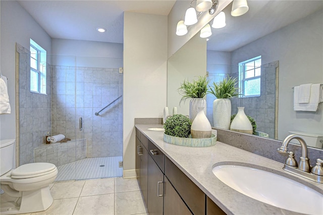 bathroom featuring toilet, vanity, tile patterned floors, and a shower with shower door