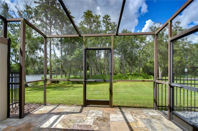 unfurnished sunroom featuring a water view