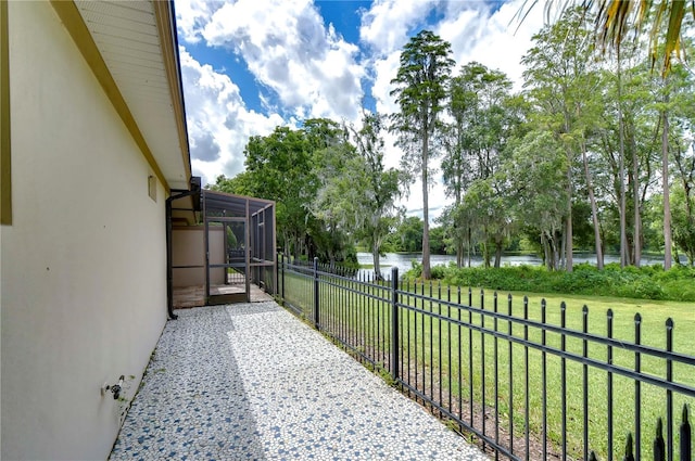 view of patio / terrace featuring glass enclosure and a water view